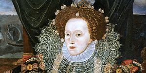 queen elizabeth i wears an ornate collar on her large dress, her hair is adorned with large pearls and other jewelry