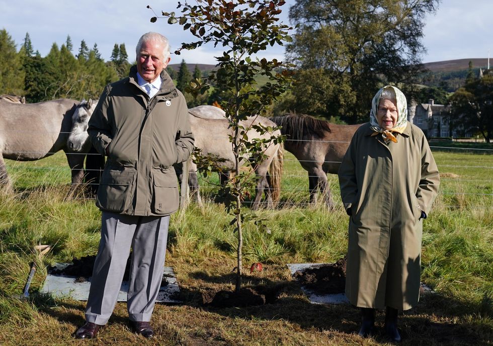 2grgkk0 queen elizabeth ii and prince of wales plant a tree at balmoral cricket pavilion to mark the start of the official planting season for the queen's green canopy qgc at the balmoral estate picture date friday october 1, 2021