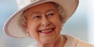 queen elizabeth lachend op de foto met witte hoed