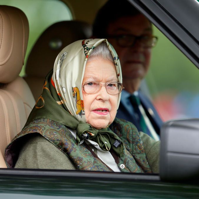 queen elizabeth, wearing a headscarf and glasses, drives her range rover to the windsor horse show