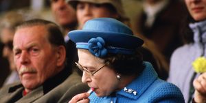 Queen Elizabeth II putting on lipstick