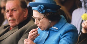 Queen Elizabeth II putting on lipstick