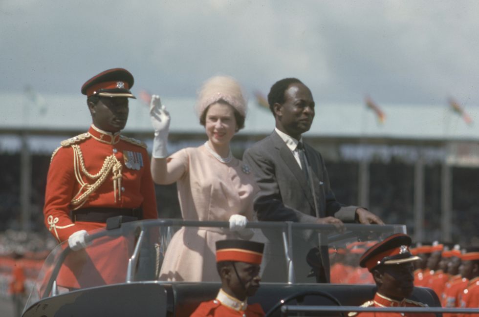 Queen Elizabeth II waves to spectators as she and President of Ghana Kwame Nkrumah drive into Black Star Sqaure in an open top car, Accra, Ghana, November 9, 1961.