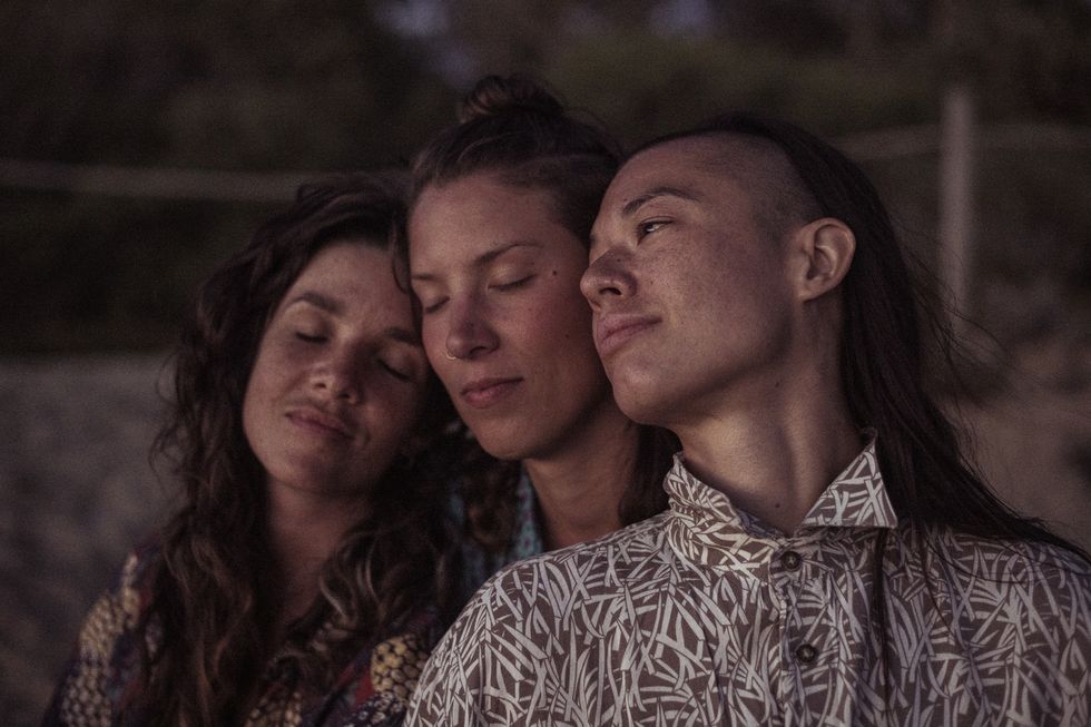 queer female thrupple relax peacefully together at dusk in portugal