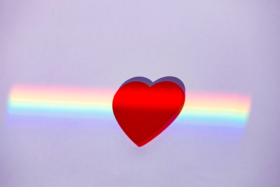 a red heart on a rainbow background