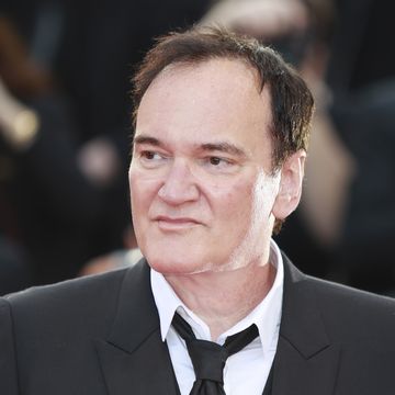 quentin tarantino in a suit and tie and looking to his right