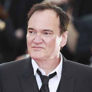 quentin tarantino in a suit and tie and looking to his right