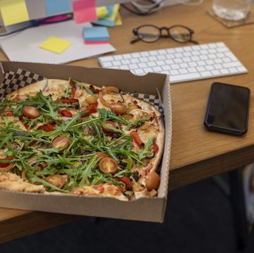 a takeaway pizza and a smartphone on a desk