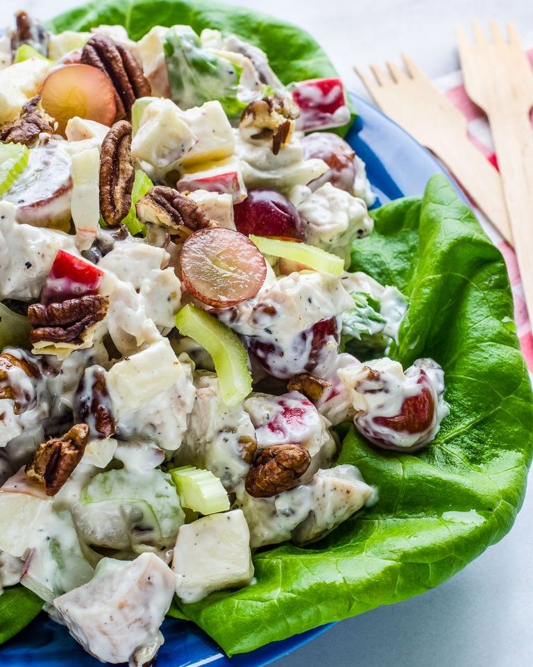 chicken waldorf salad over bed of lettuce with wooden forks