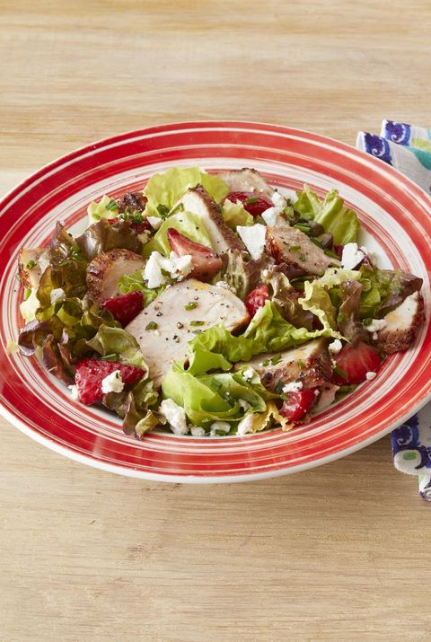 grilled pork salad with strawberries in red bowl
