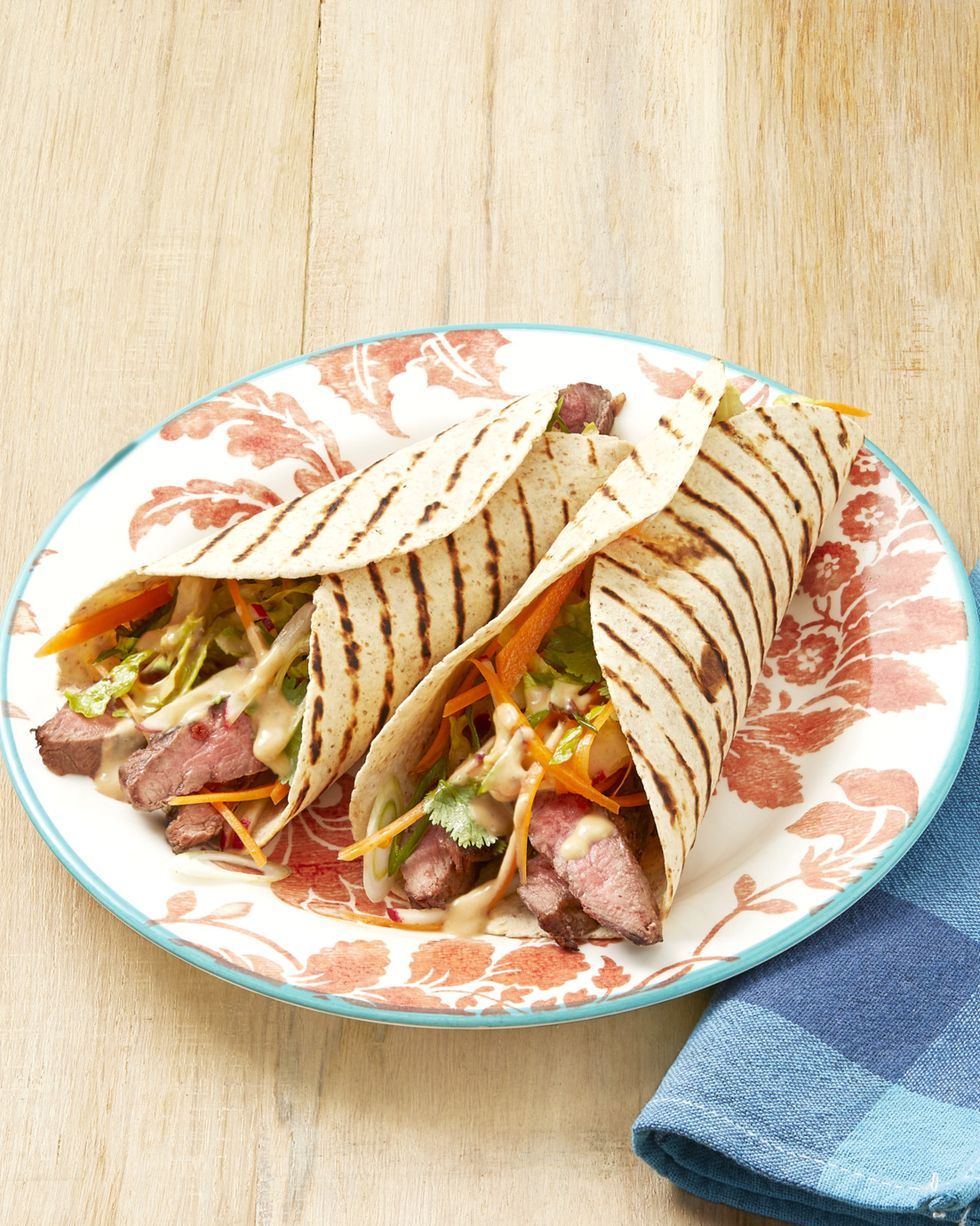 grilled steak wraps with peanut sauce on red floral plate