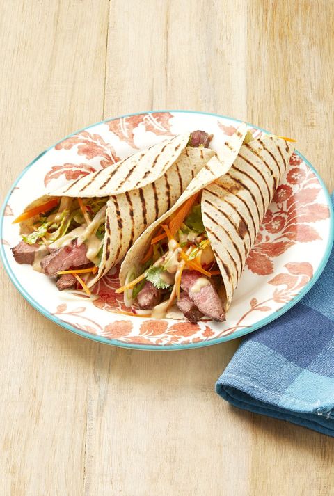 grilled steak wraps with peanut sauce on red floral plate