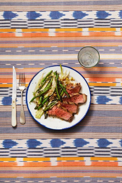 steak with grilled green beans, fennel  farro on a white plate