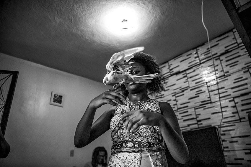 Een sambadanseres speelt met haar tamme valkparkiet in haar woning in een favela in Rio de Janeiro De samba heeft zijn oorsprong in Afrikaanse percussie en groeide in de jaren vijftig van de vorige eeuw uit tot de energieke stijl zoals die we nu kennen