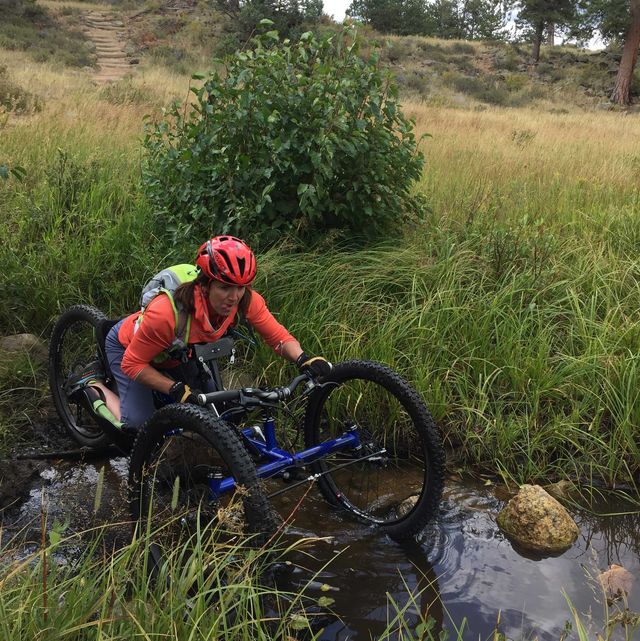 quinn brett on her adaptive cycle crossing a river