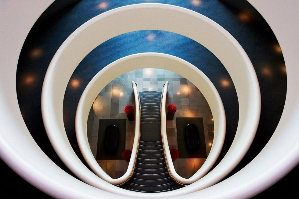 quirky, unusual hotels uk spiral staircase leading down with circular railings and decorative elements