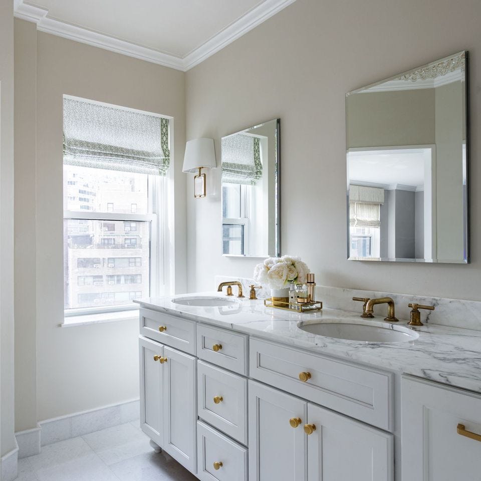 a bathroom with white cabinets