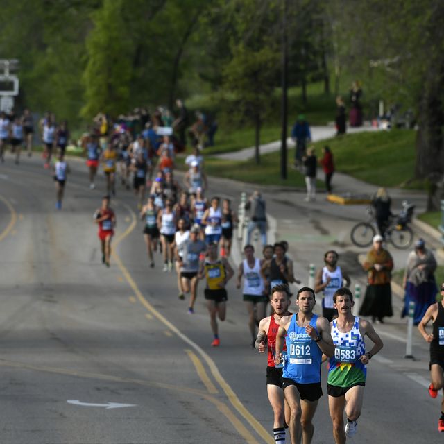 runners in a race on a wide road through a park