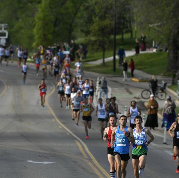 runners in a race on a wide road through a park