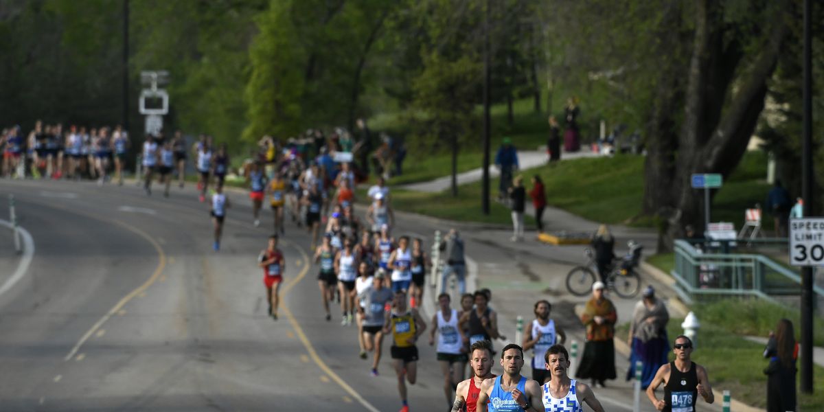 runners in a race on a wide road through a park