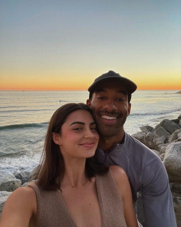 a couple taking a selfie at the beach during sunset