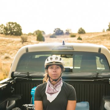 rachel olzer sitting in back of truck wearing a helmet and bandana