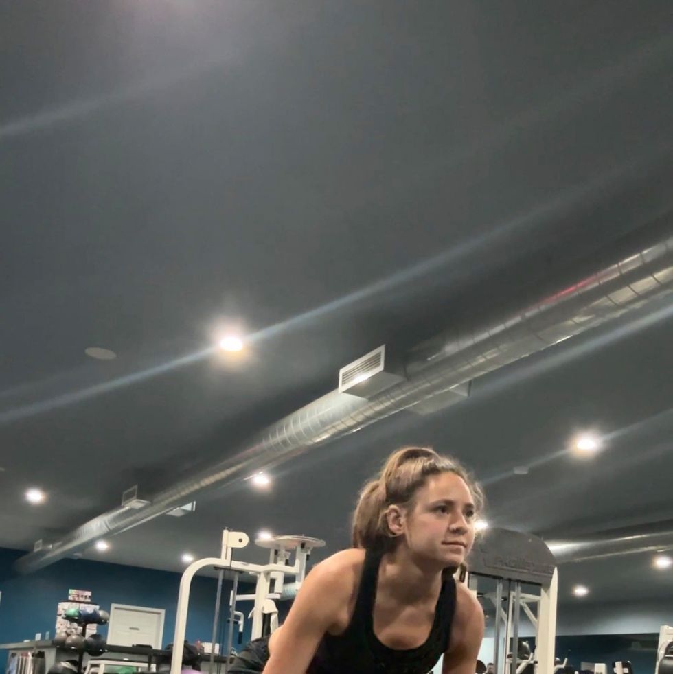 a woman doing a deadlift in a gym