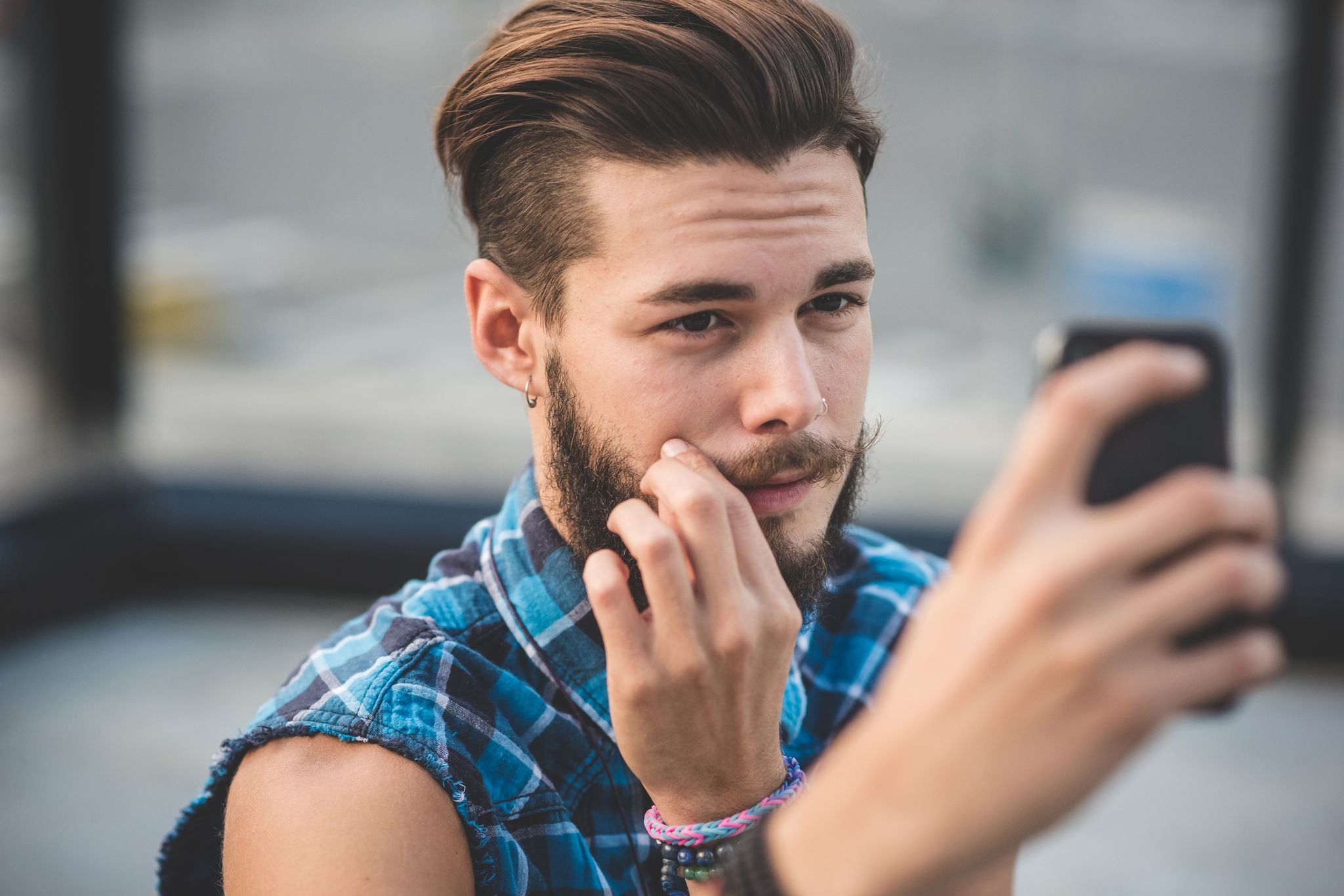 Un ragazzo si specchia con lo smartphone come un narcisista