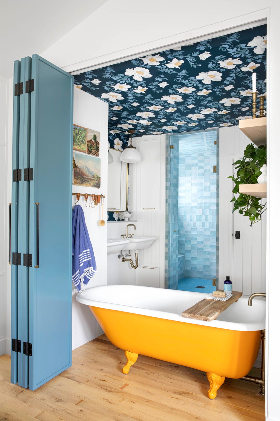 bathroom with a yellow clawfoot tub and floral wallpaper on ceiling