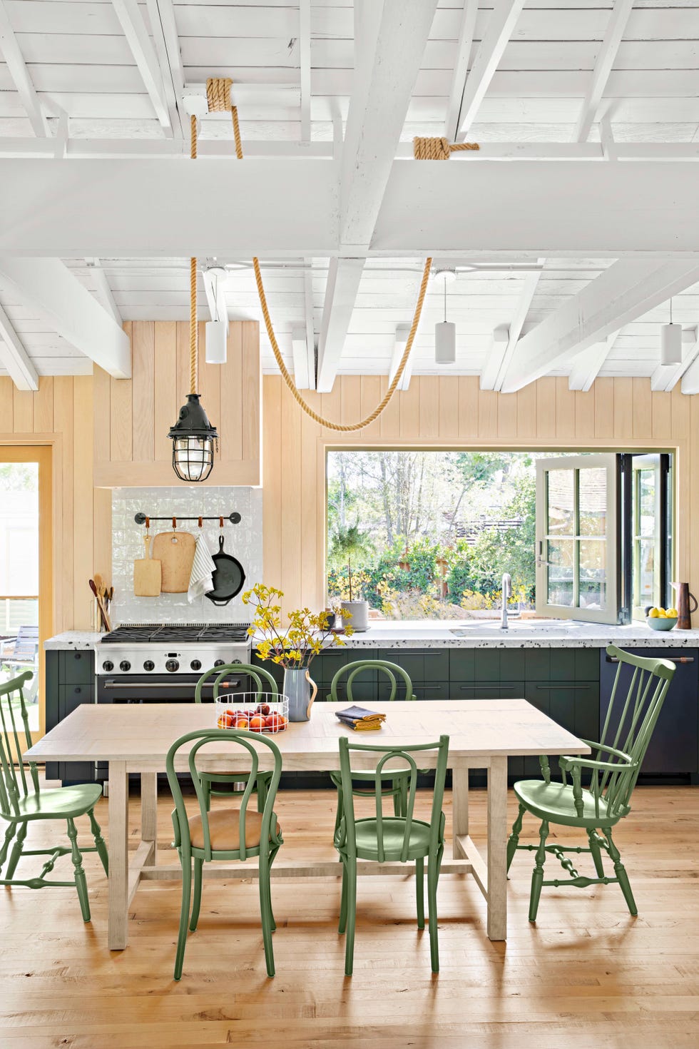 modern white eat in kitchen with mismatched green chairs