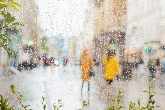 rain on a window, looking out to people in a street scene