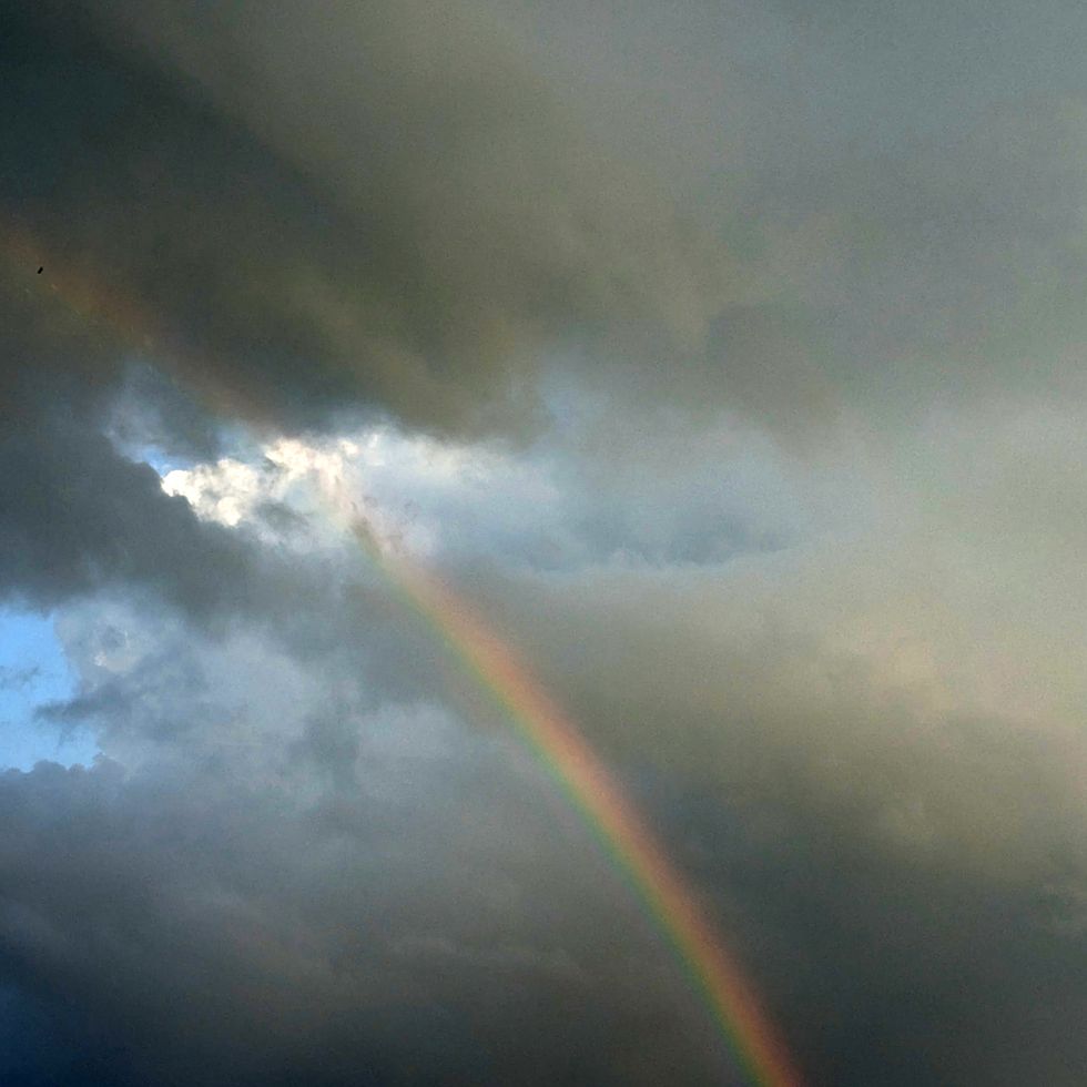 rainbow breaking through dark clouds