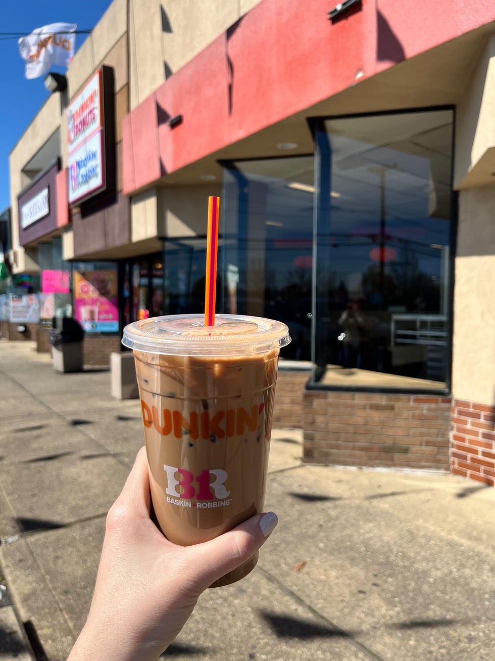 ice dunkin drink held outside a dunkin store