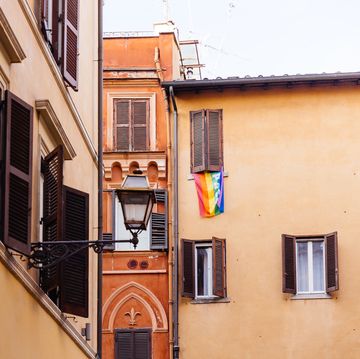 rainbow flag hanging from the window of the residential building in rome, italy