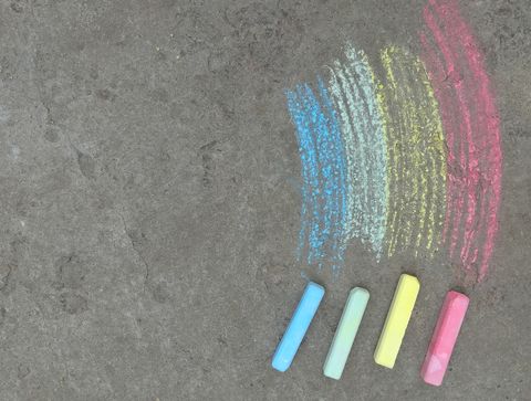 rainbow is drawn with chalk on the asphalt colored summer background children drawing, lgbt symbol copy space, place for text