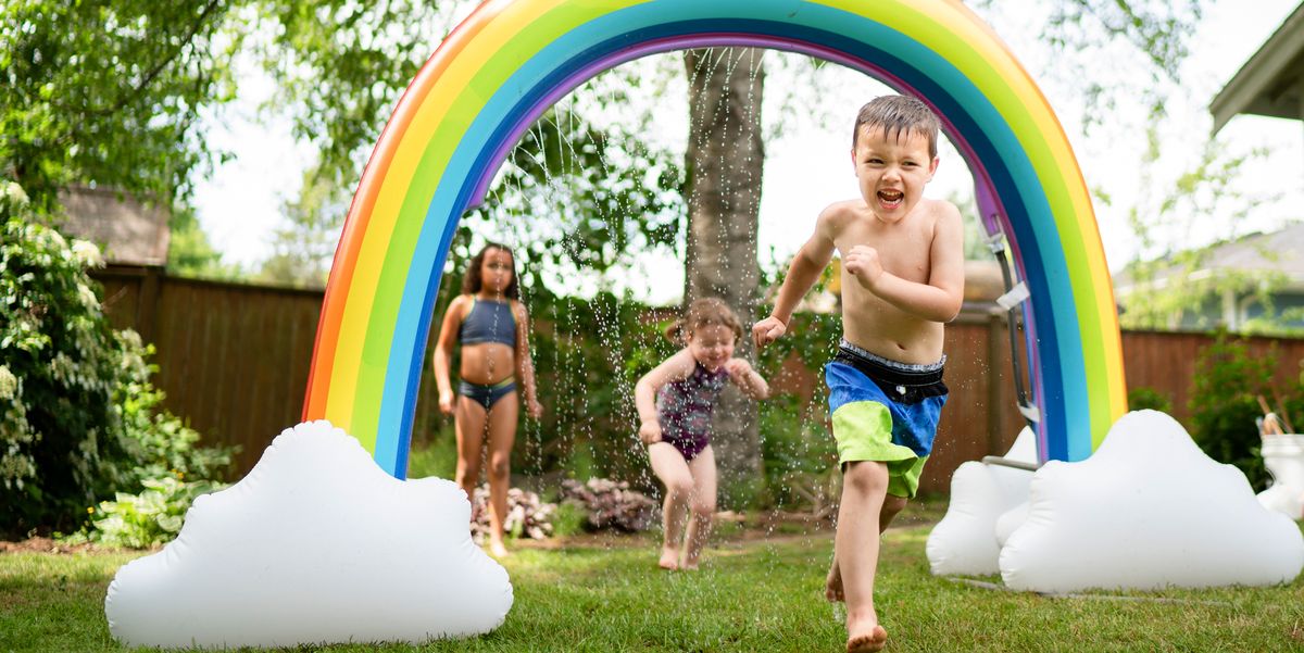 kids running through rainbow sprinkler