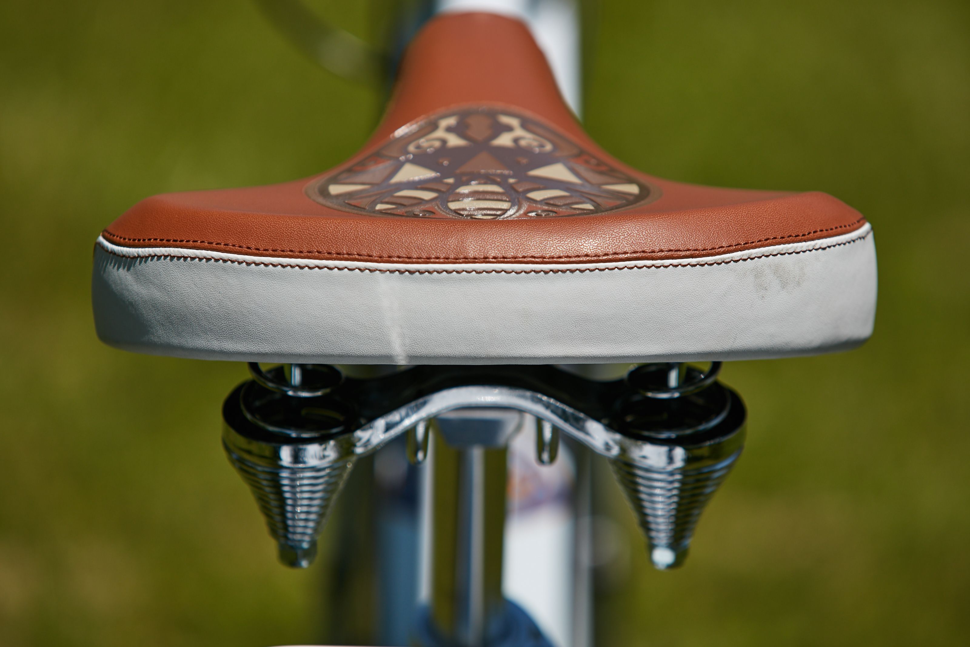 Bicycle part, Bicycle saddle, Orange, Bicycle, Bicycle wheel, Bicycle handlebar, Vehicle, Shoe, Sports equipment, 