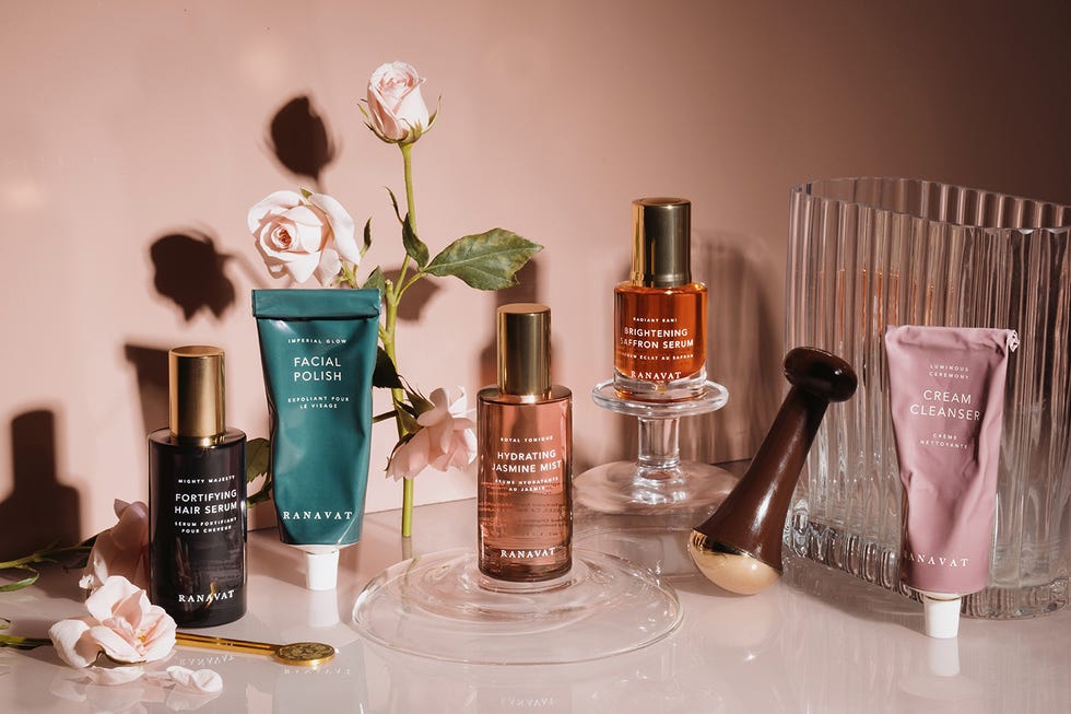 skincare bottles on glass table with flowers surrounding