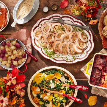 a table set with plates of food including turkey roulade, winter salad, biscuits, root vegetable gratin, and sweet and sour onions