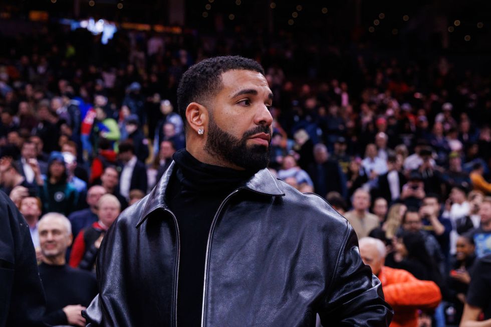 drake looking out of frame at a basketball game