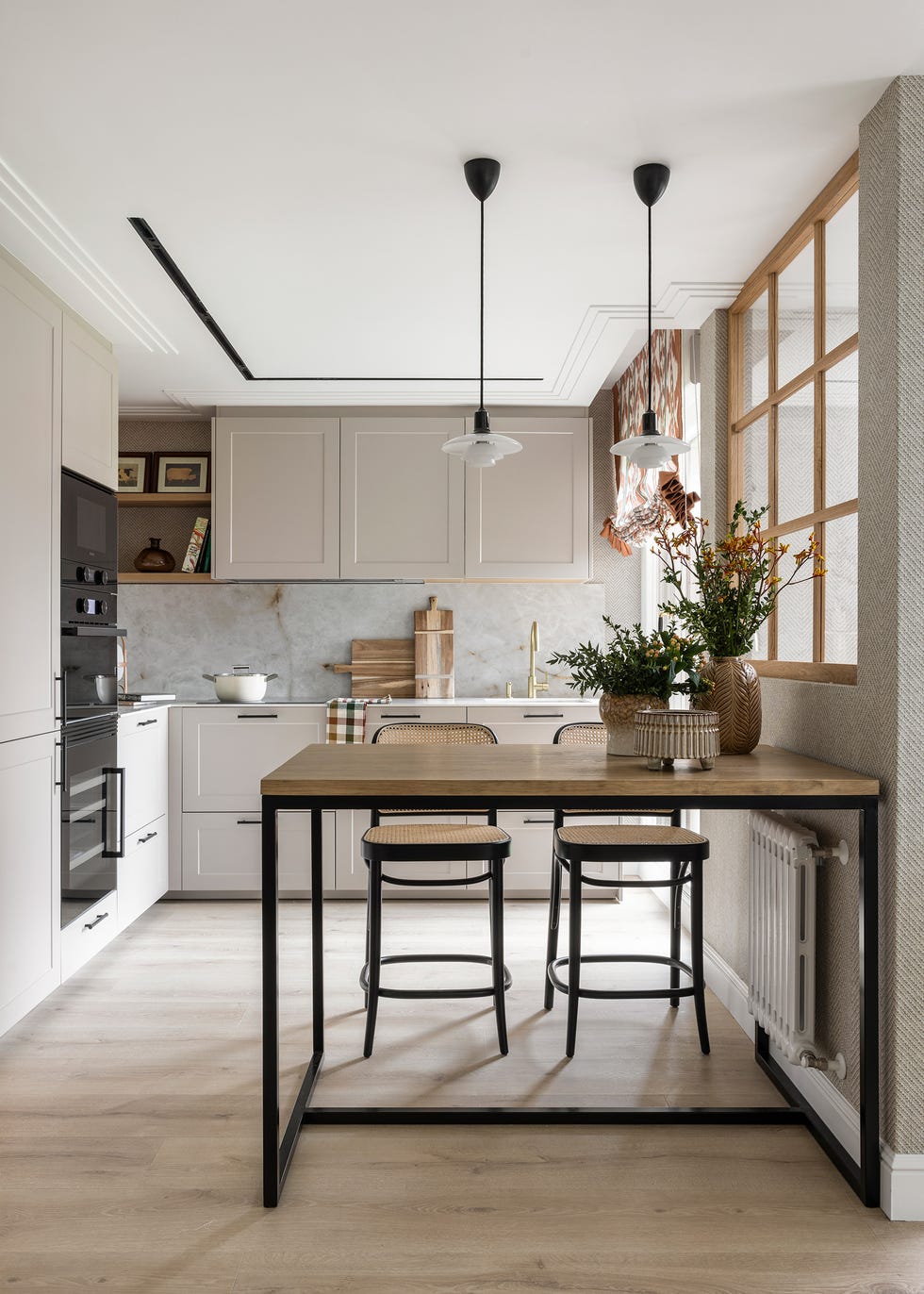 cocina con muebles en color topo y mesa de comedor de madera y hierro
