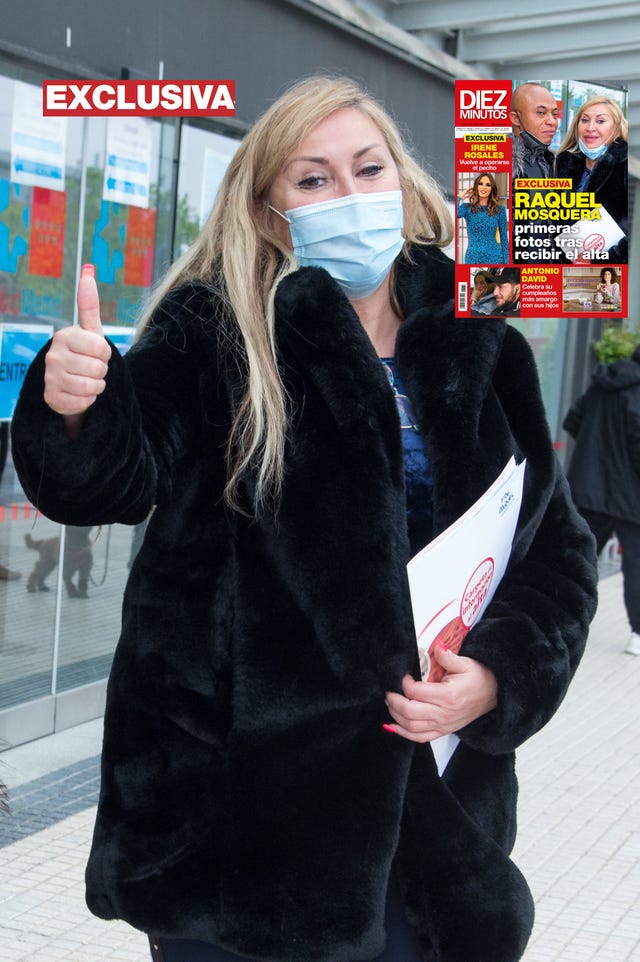 la peluquera, con mascarilla y el pulgar hacia arriba, posa para los fotógrafos tras recibir el alta en el hospital