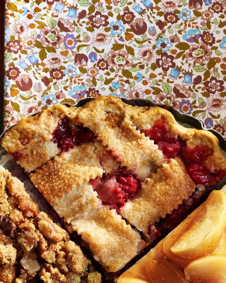 a quarter of an apple and raspberry pie in a pie pan with three other quarters of different flavors