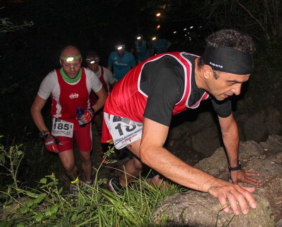 a group of men wearing numbers and running on a log