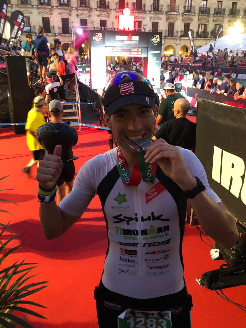 el triatleta vasco raúl pérez mordiendo una medalla tras terminar un triatlón de larga distancia