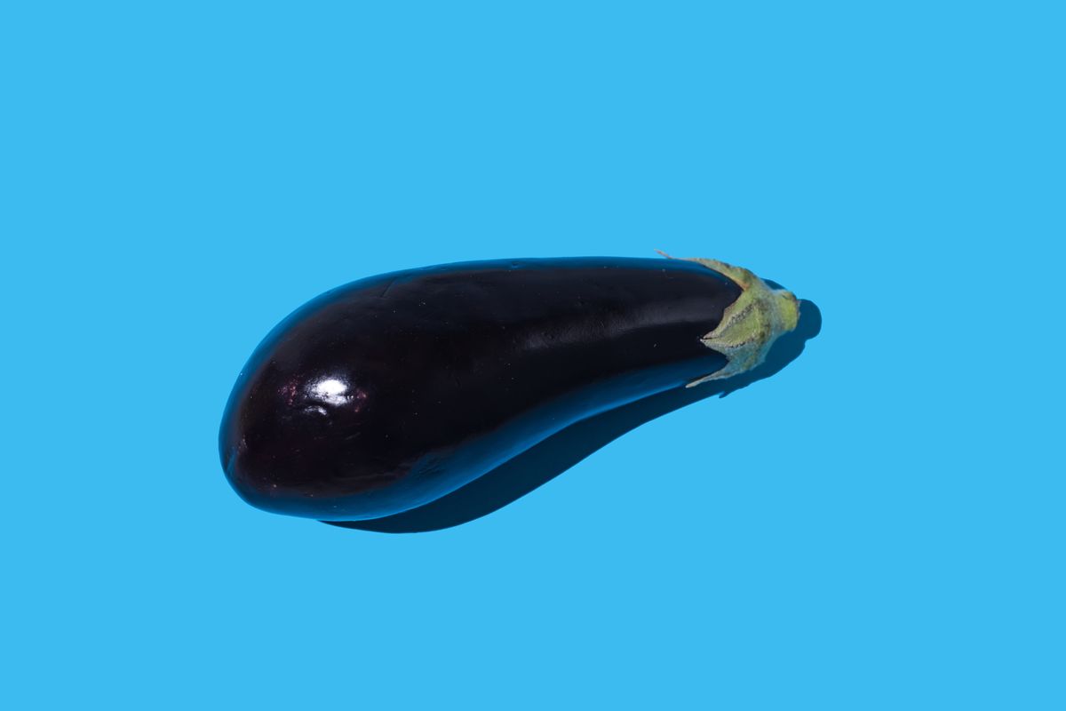 raw eggplant with hard shadow on blue background concept of vegetable, healthy food, vegetarian food, veganism, food, garden and fresh food