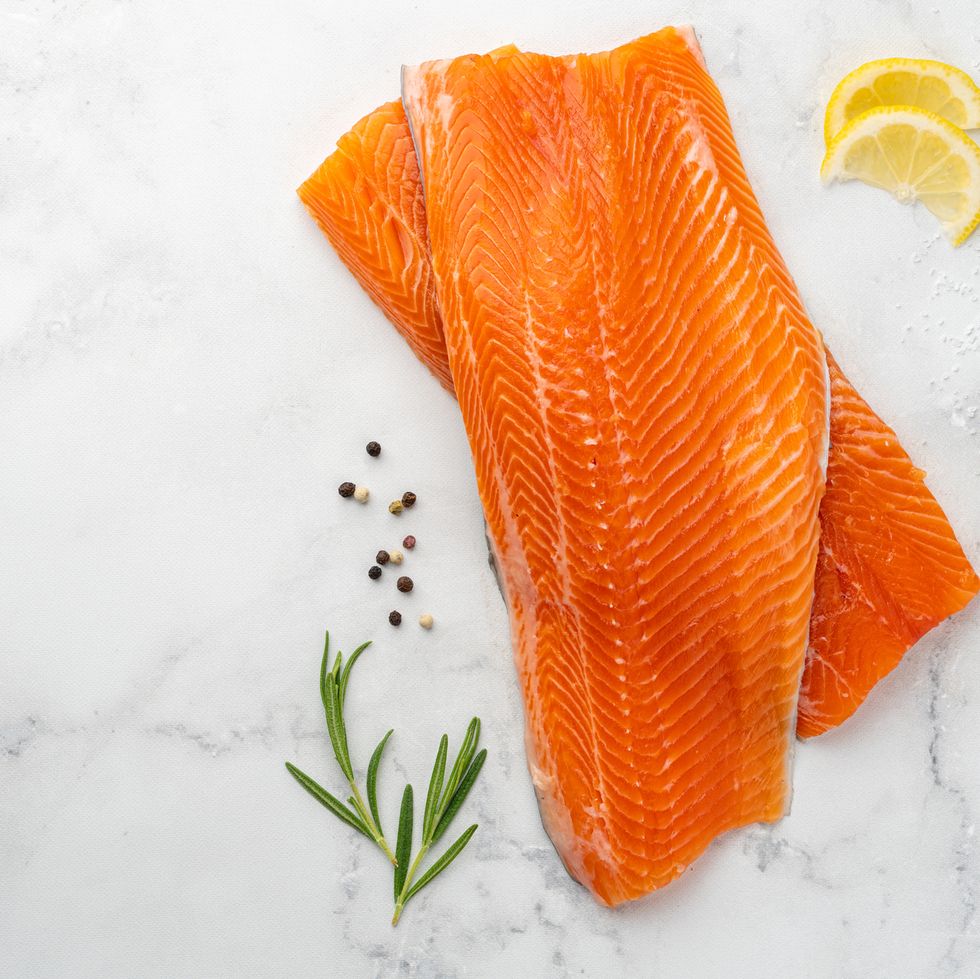 raw lake trout fillets on marble table top fresh fish with lemon slices, pepper seasoning and rosemary protein and omega 3 mediterranean food cooking healthy eating meal preparing dieting organic dish lunch ingredient horizontal, copy space