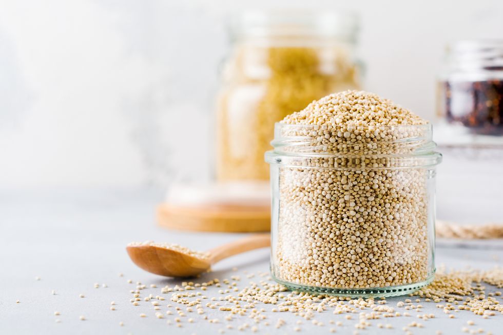 raw quinoa grains in jar healthy vegetarian food on gray kitchen table selective focus