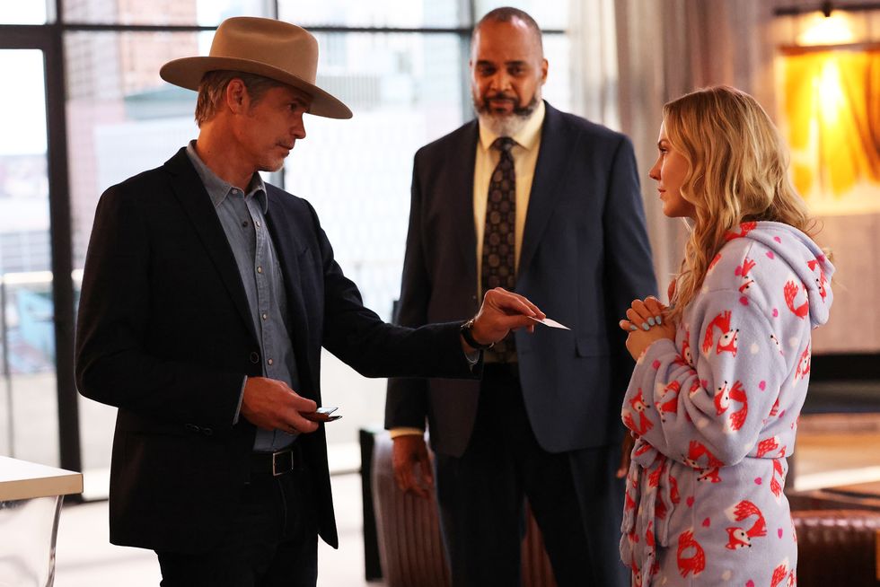 raylan, played by olyphant, hands his card to sandy, played by clemens, also shown, victor williams as wendell