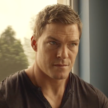 alan ritchson as jack reacher in amazon series reacher, sitting in a cafe wearing a black tshirt